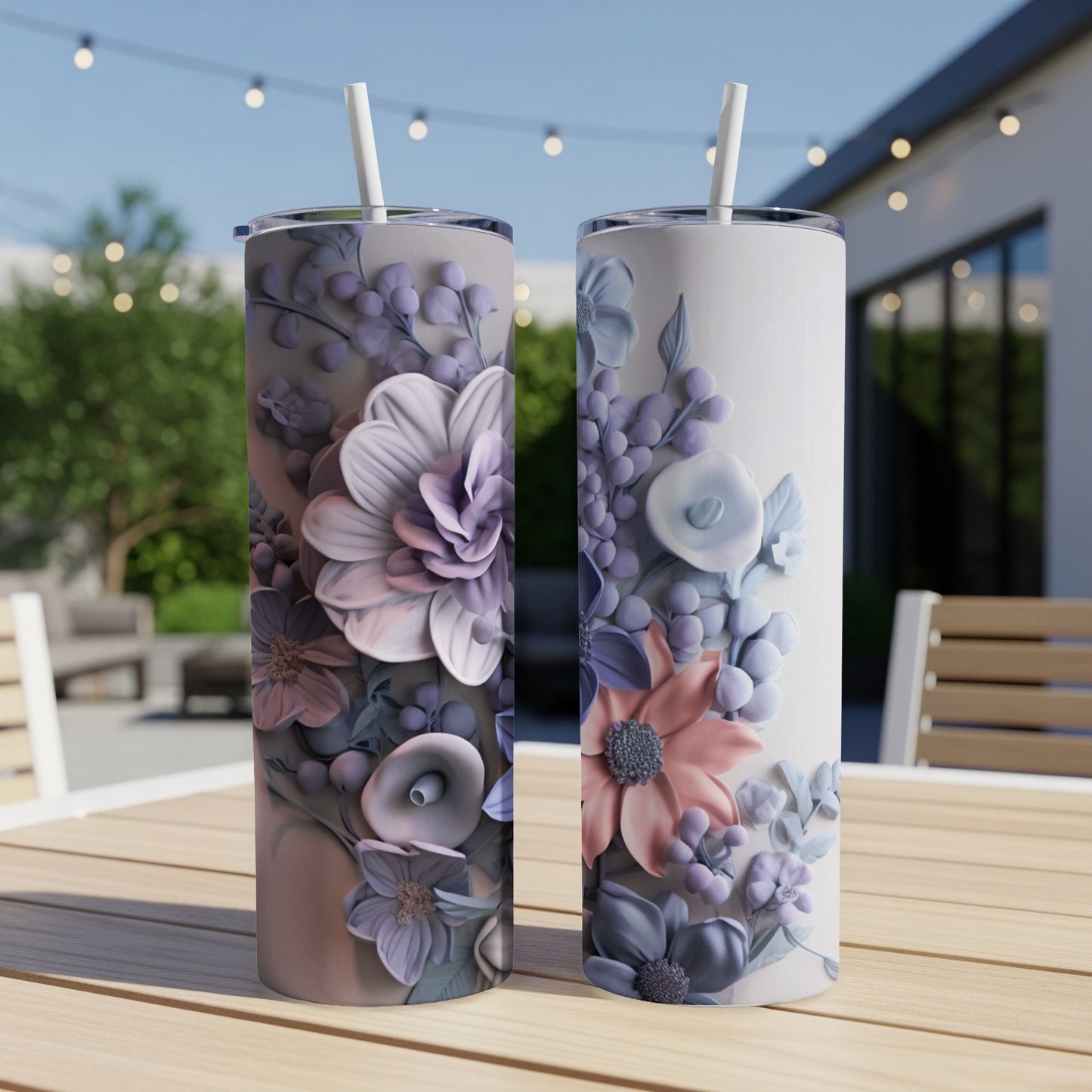 Two tall tumblers with floral designs on a wooden table.
