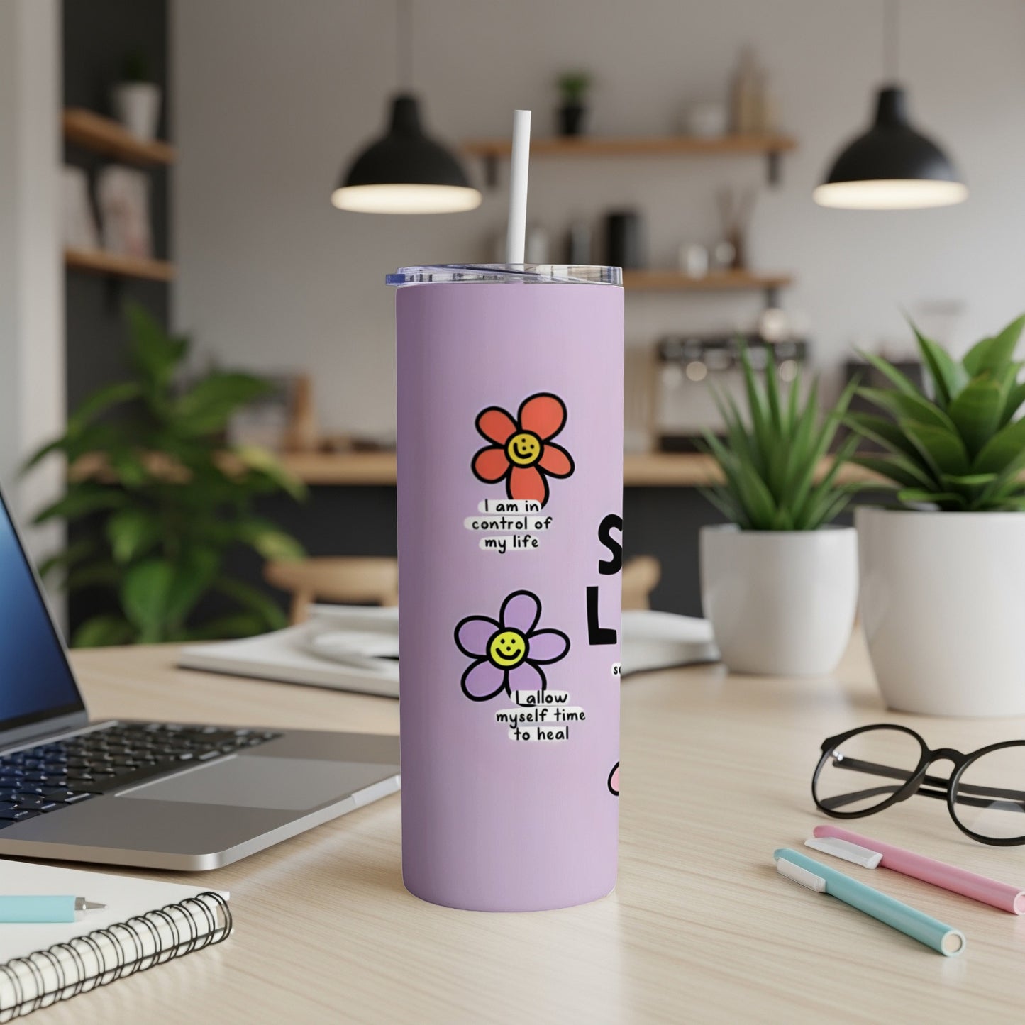 Purple tumbler with floral and text designs.