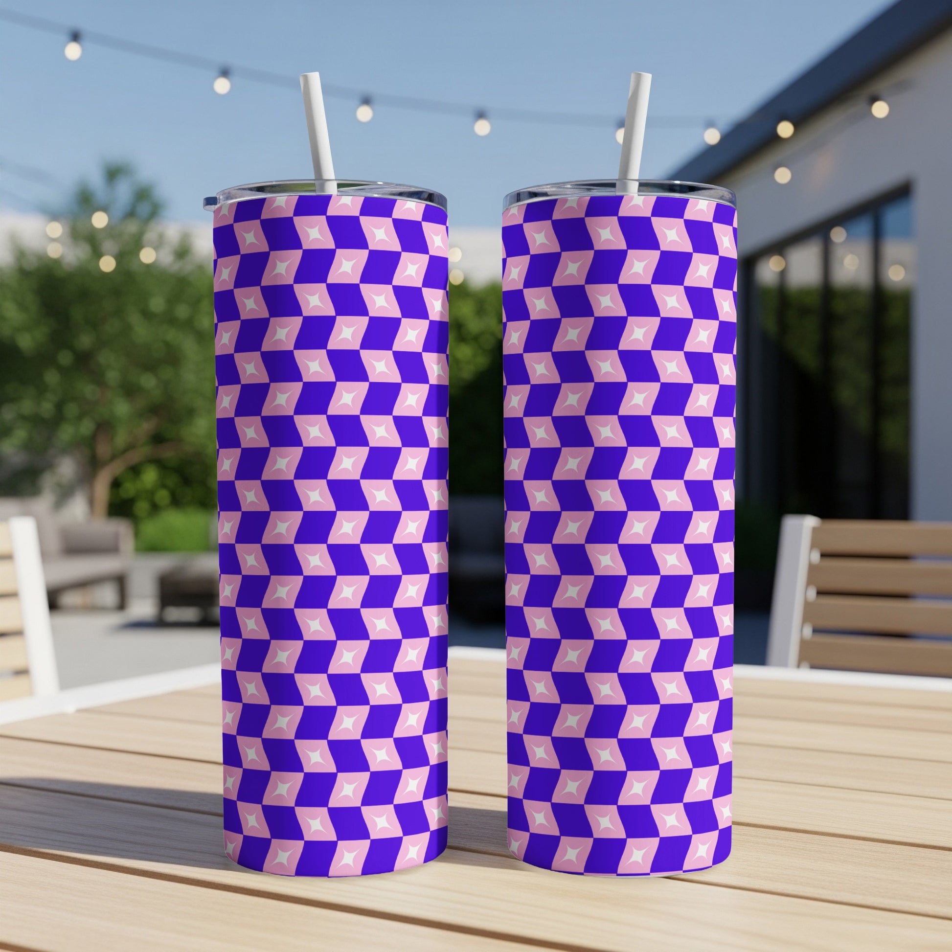 Two tall tumblers with a pink and purple diamond pattern sit on a wooden table.