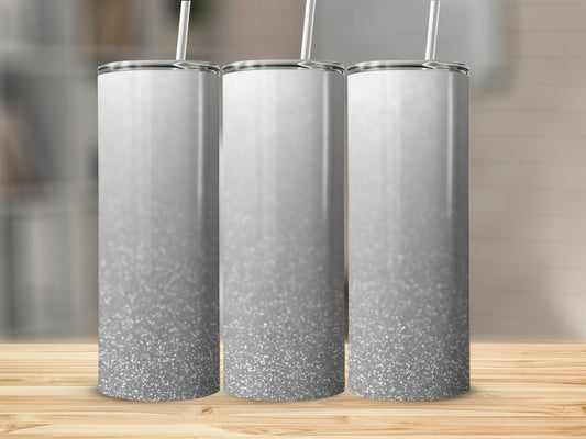 Three glitter tumblers with white lids and straws, on a wooden surface.