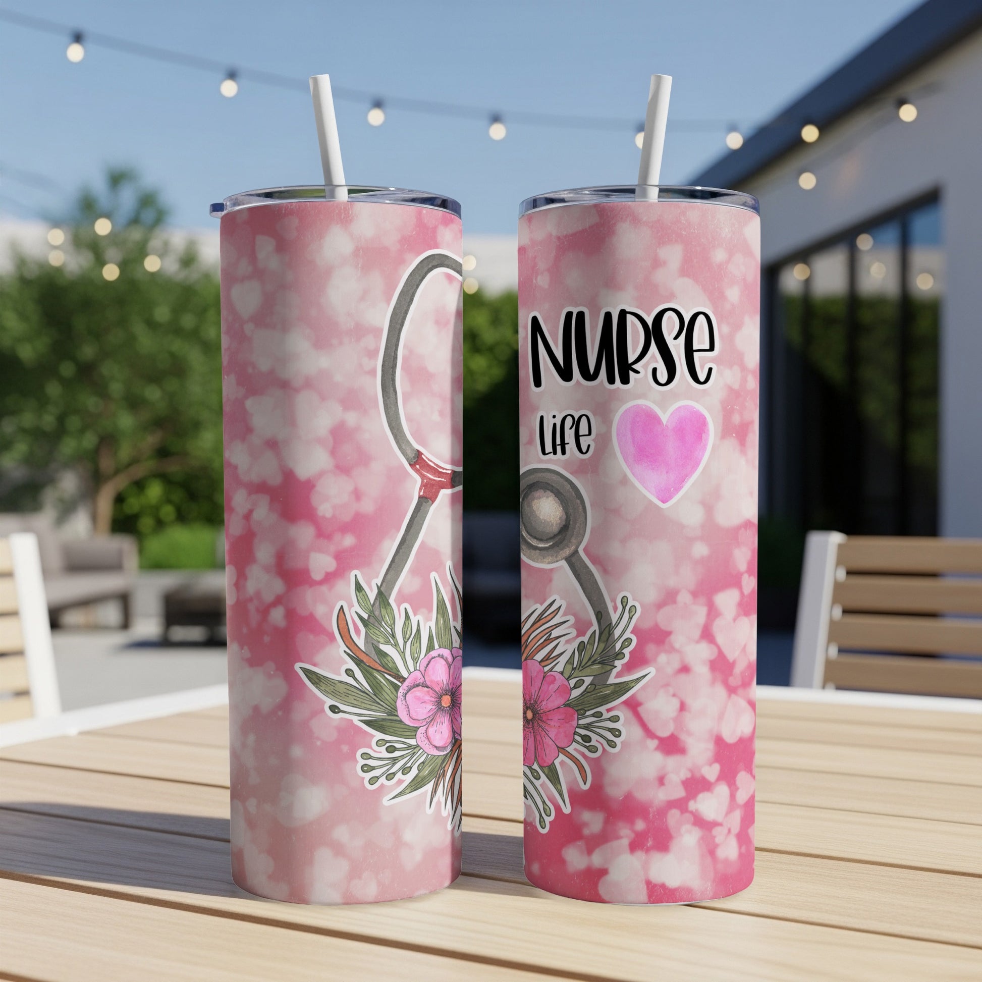 Two nurse life tumblers with stethoscope and floral design on a patio table.