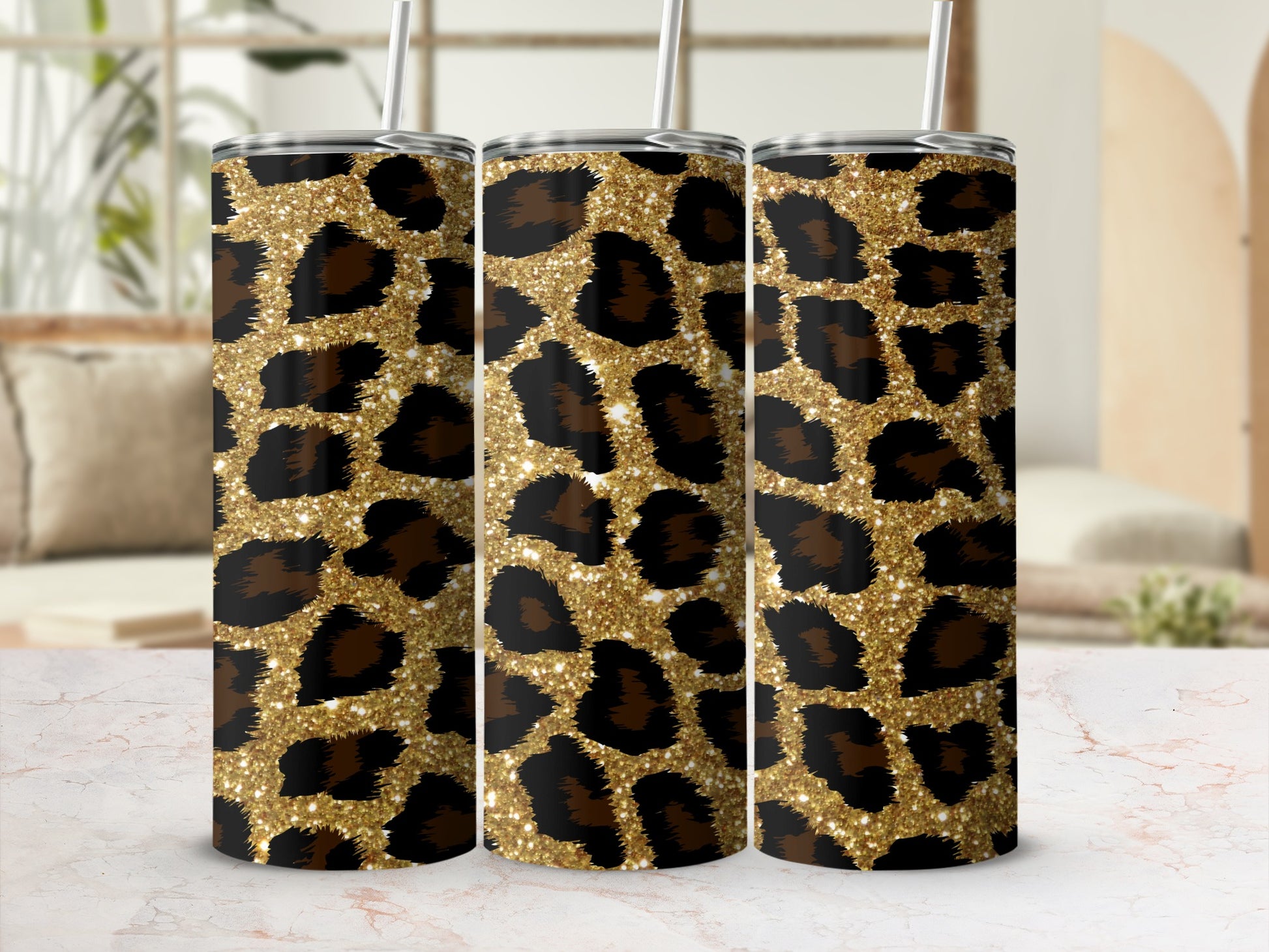 Three tumblers with a gold glitter leopard print design and silver straws.