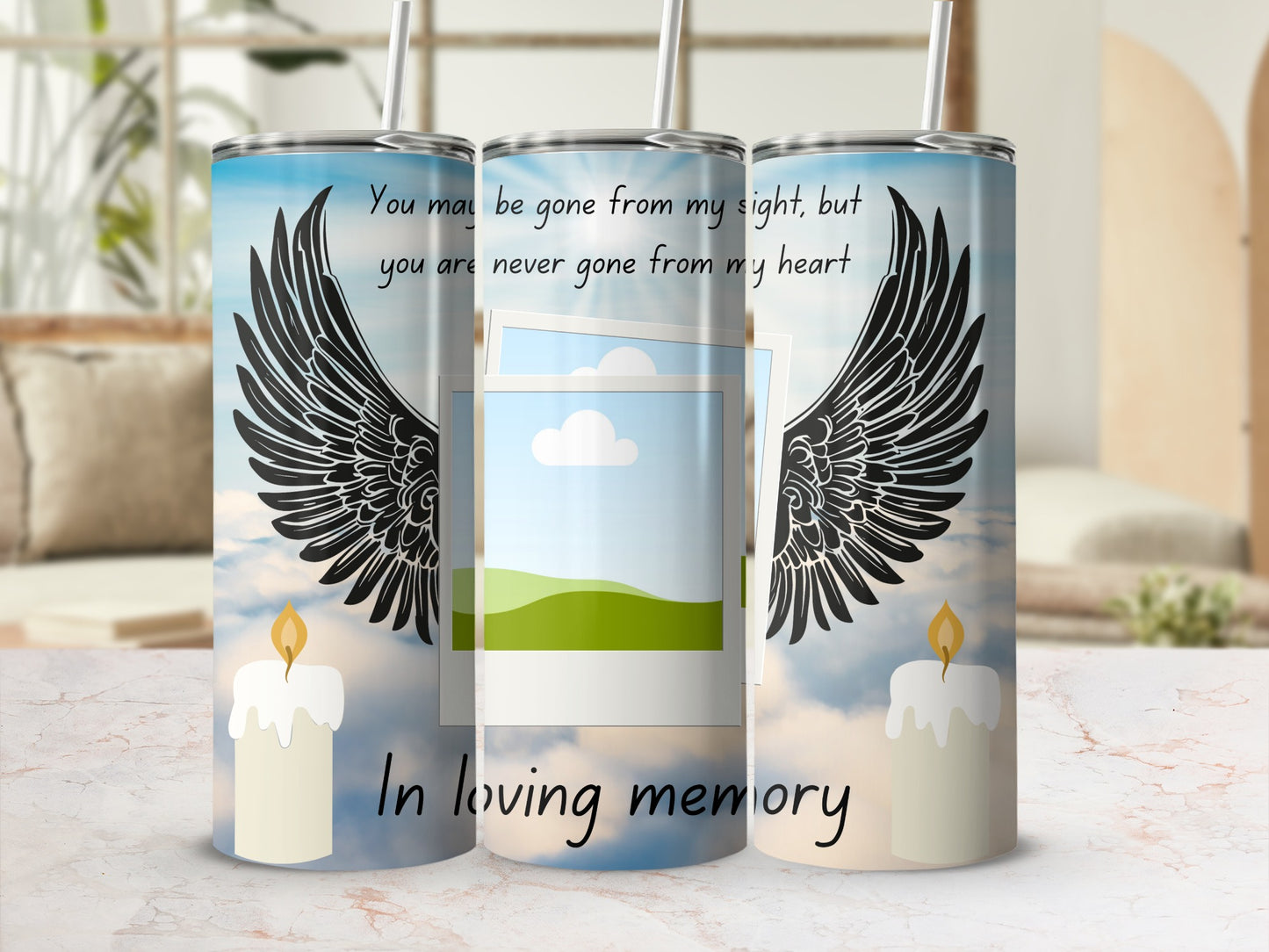 Tumbler with angel wings, lit candle, and "In loving memory" text.