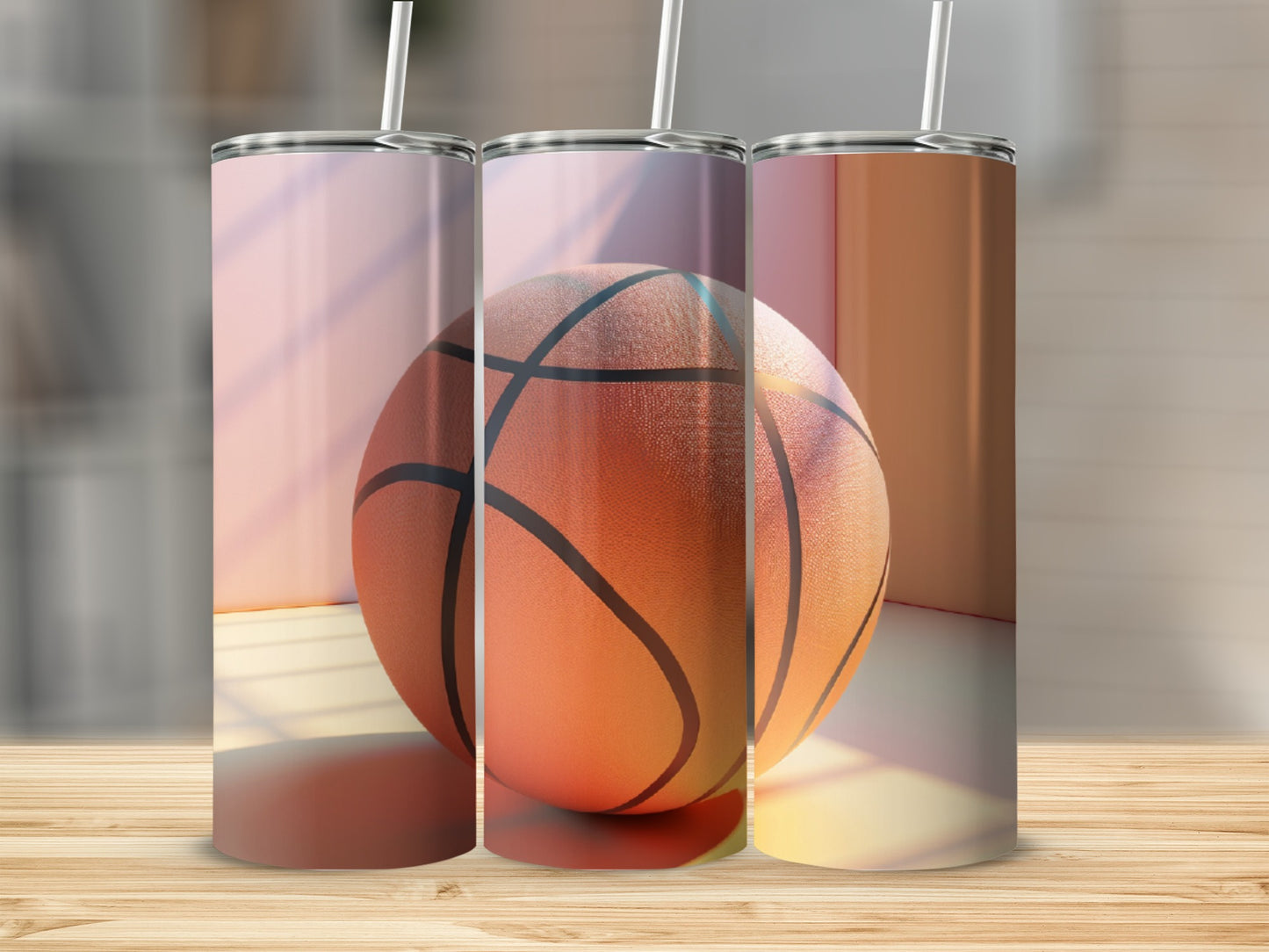 Three basketball tumblers with straws on a wooden surface.