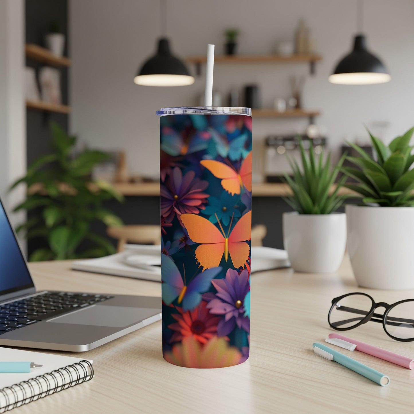 Tall tumbler with colorful butterflies and flowers, white straw in a modern kitchen.