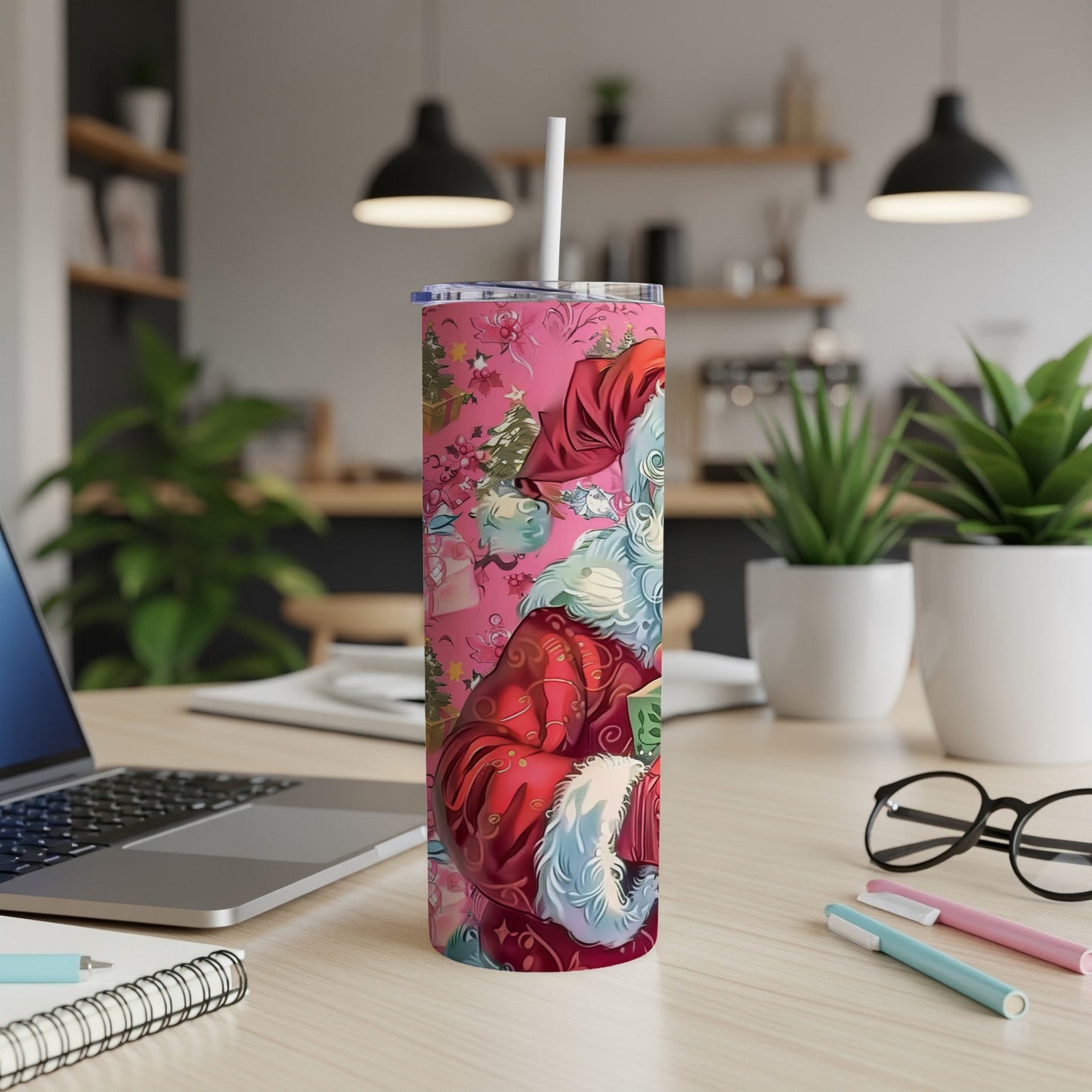 Pink tumbler with Santa Claus pattern, holding a gift, with a straw.