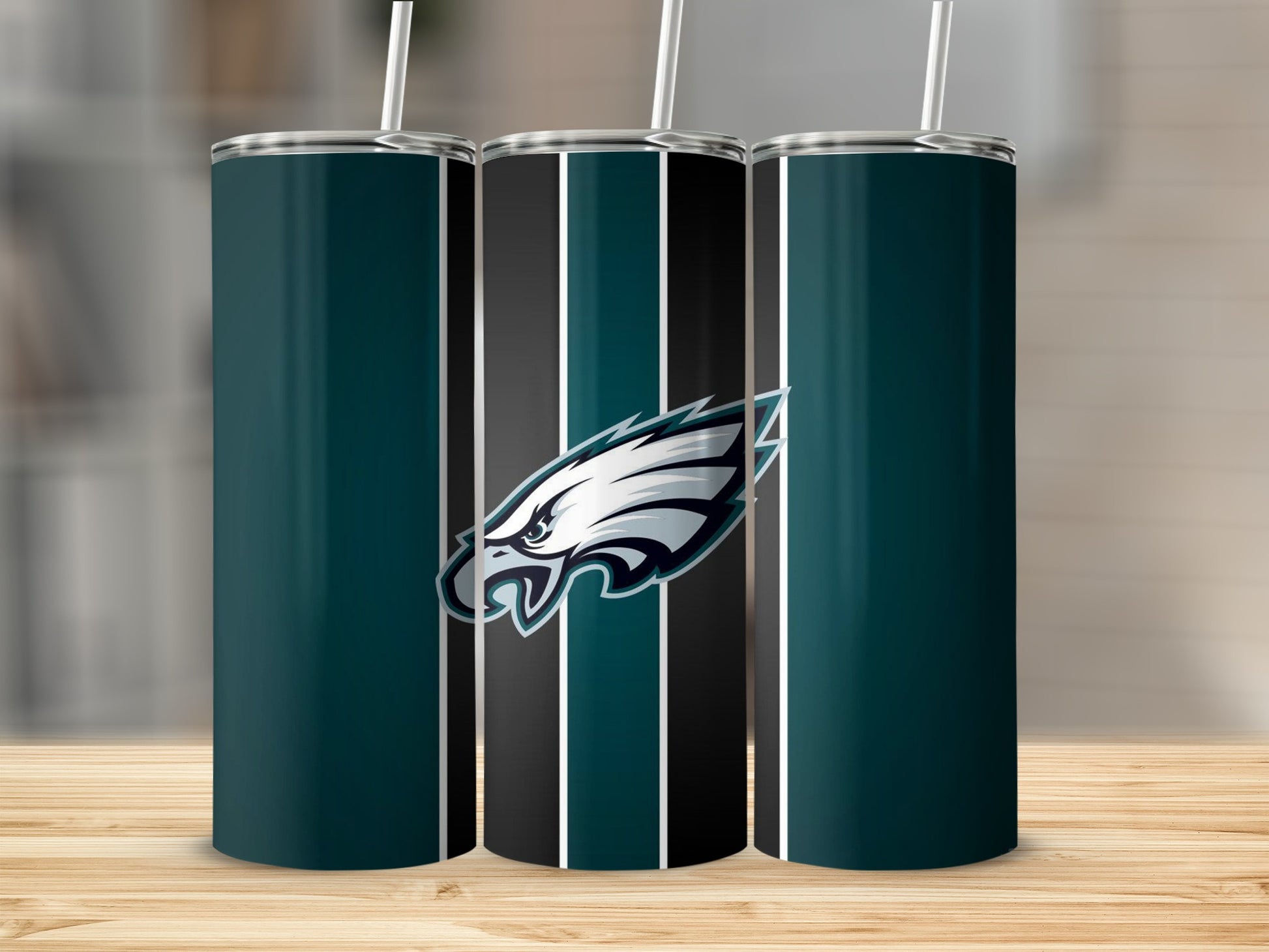 Philadelphia Eagles logo on a striped teal and black tumbler with straw.