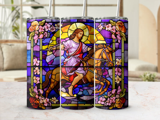 Stained glass tumbler with Jesus on horseback surrounded by floral designs.