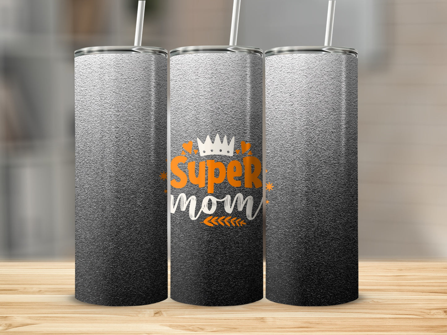 Three tumblers with "Super Mom" text and crown graphic on a wooden surface.
