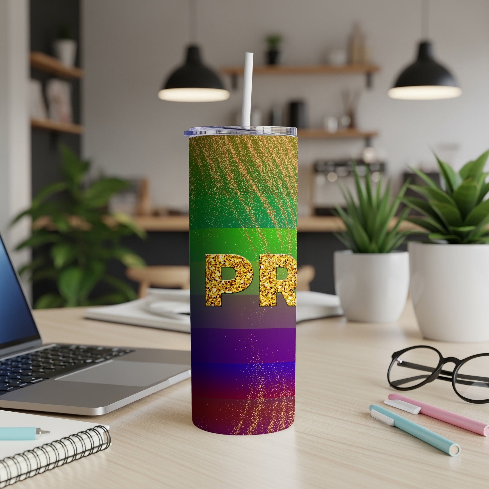Rainbow glitter tumbler with "PR" text, on a desk with a laptop.