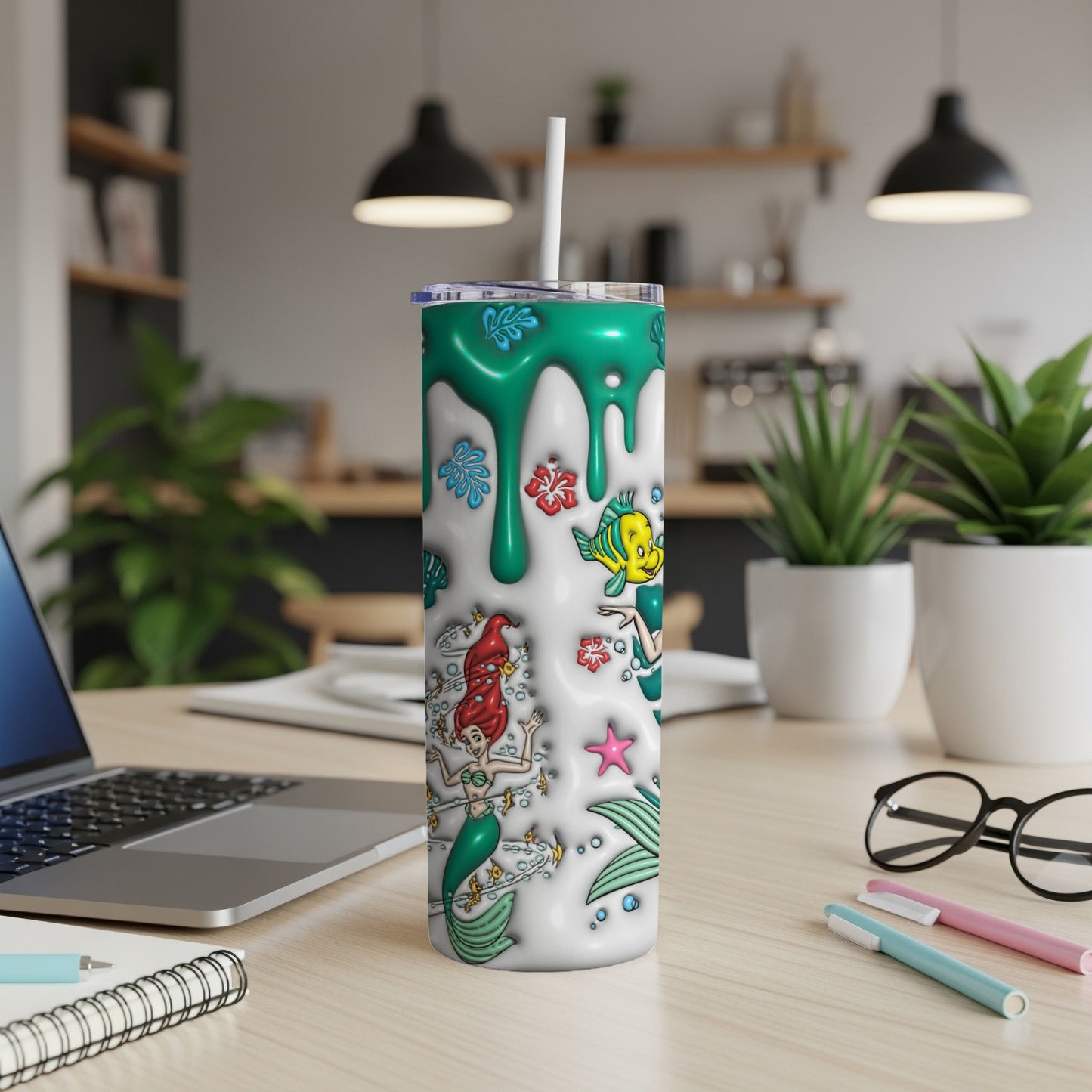 The Little Mermaid characters, Ariel, Flounder, and Sebastian, on a teal and white patterned tumbler.