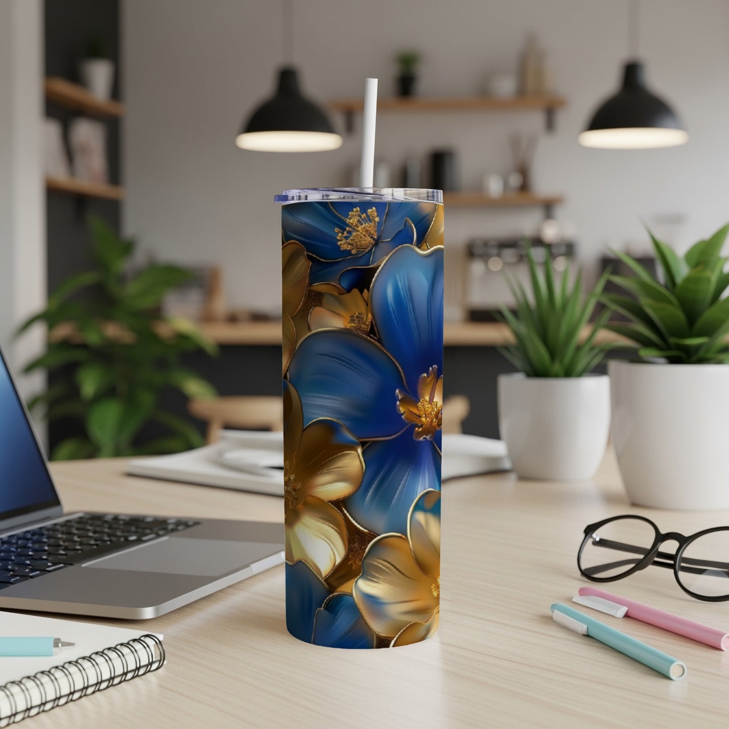 Blue and gold floral design on a tall, slender tumbler with a straw.