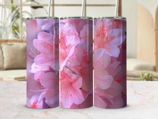 Pink floral pattern on three tumblers with straws, set against a blurred background.