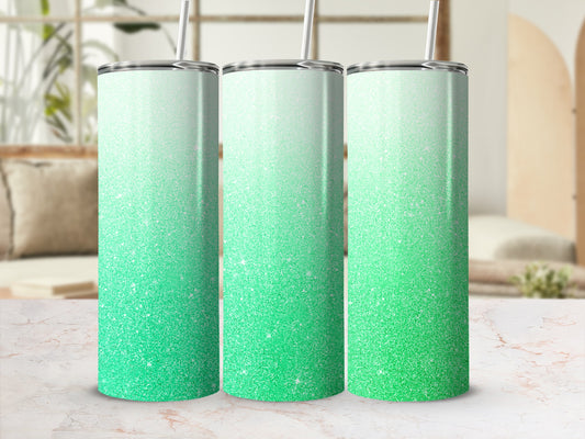 Three skinny tumblers with green ombre glitter design and straws.