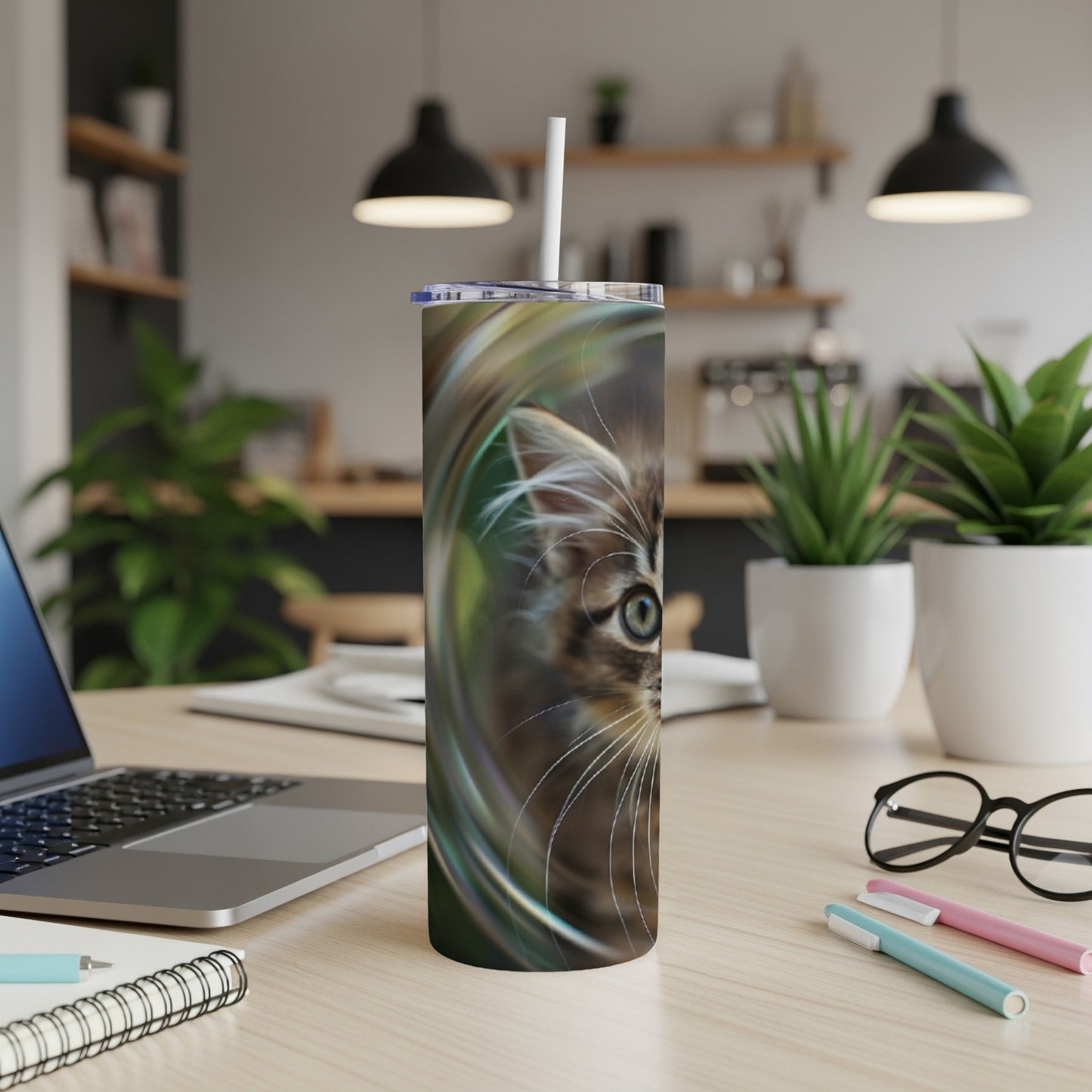 Close-up of kitten face emerging from swirling colorful abstract design on a tumbler.