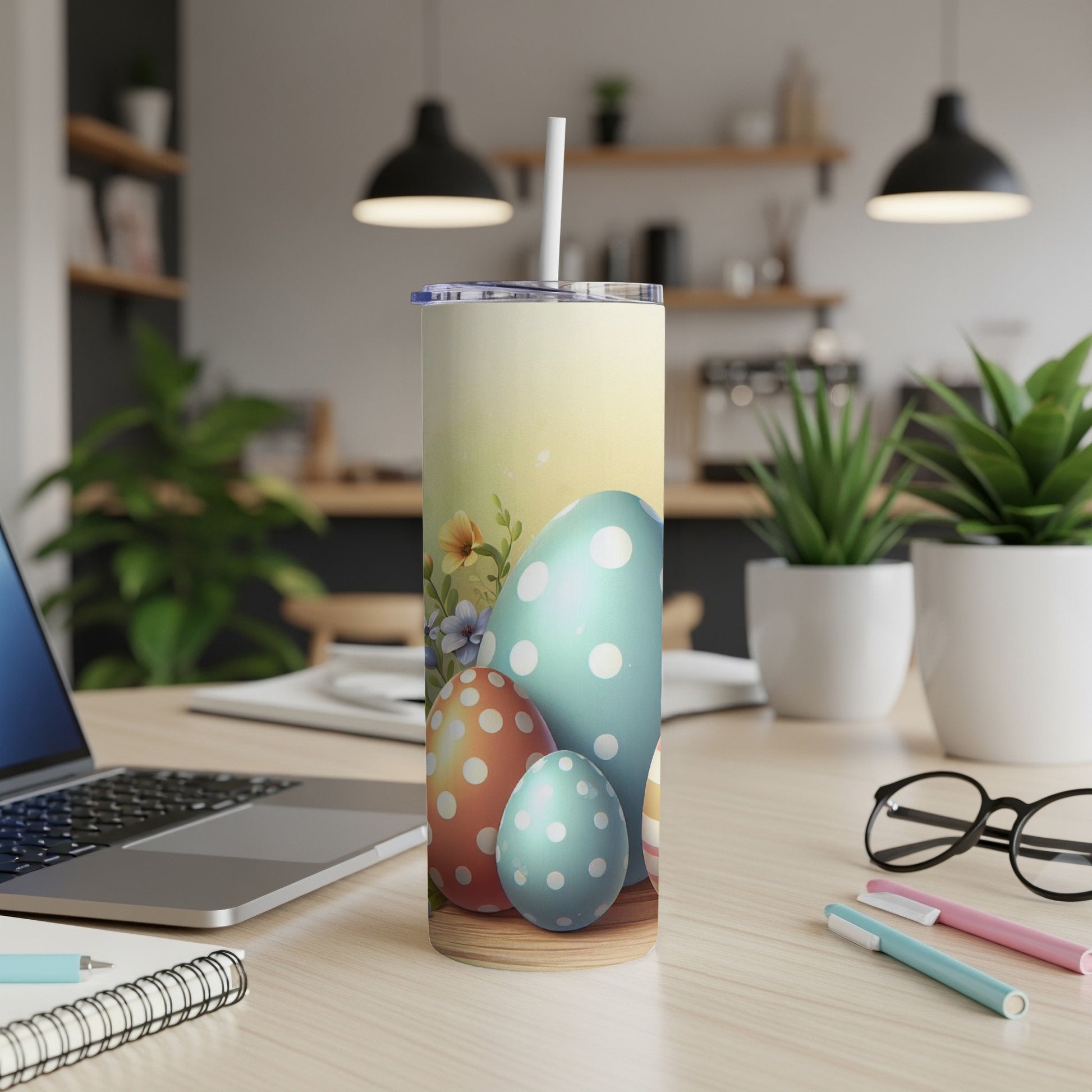 Easter egg design on a tall tumbler with straw, on a desk.