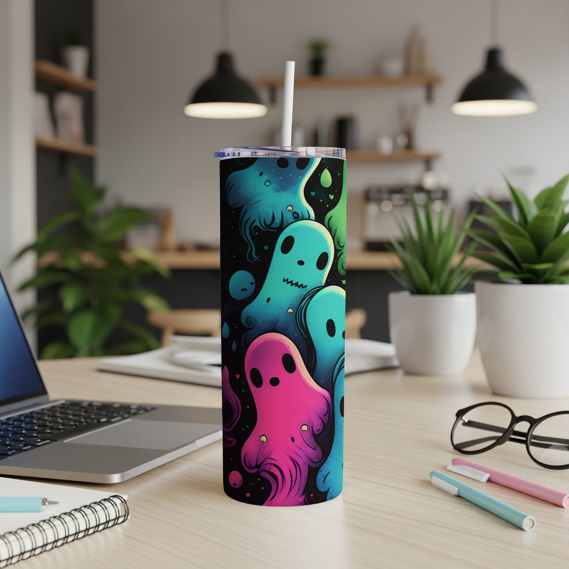 Tumbler with colorful cartoon ghosts and a white straw.