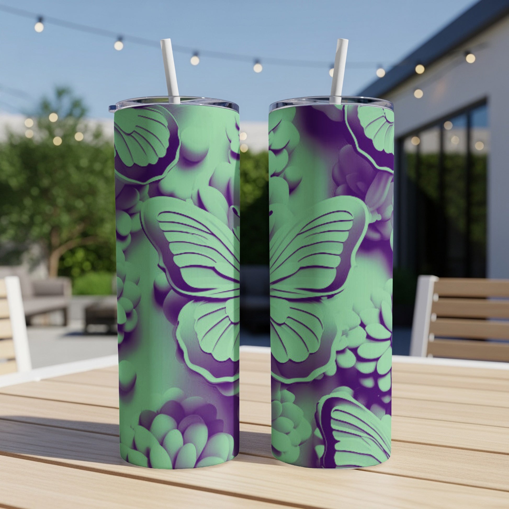 Two green and purple floral print tumblers with butterfly designs on a table.