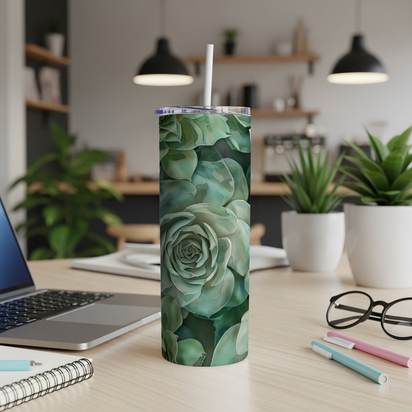 Green succulent floral pattern on a tall, slim tumbler with a white straw.