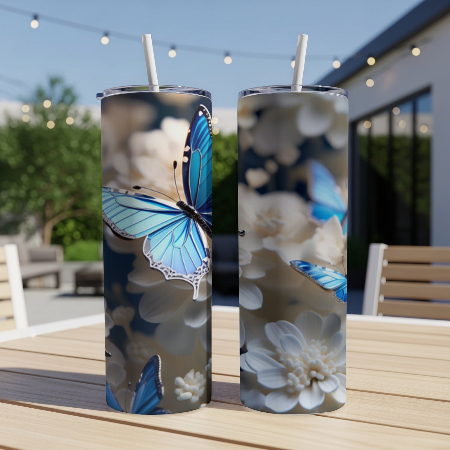 Two tumblers featuring blue butterflies and white flowers on a patio table.