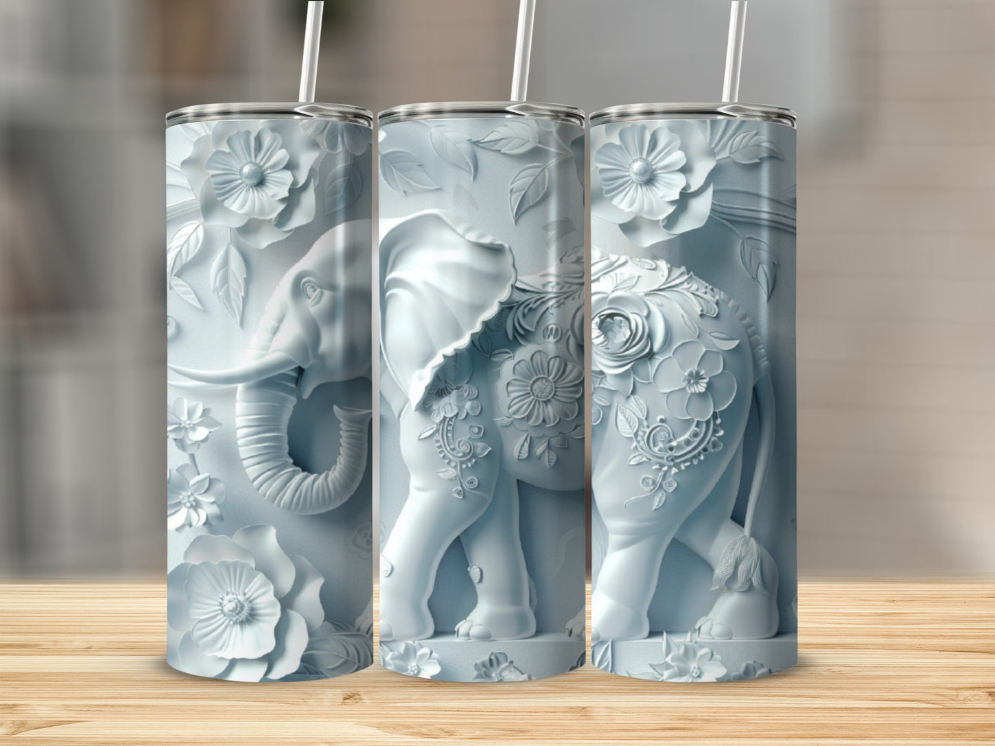 Three light blue tumblers with embossed elephant and floral designs.