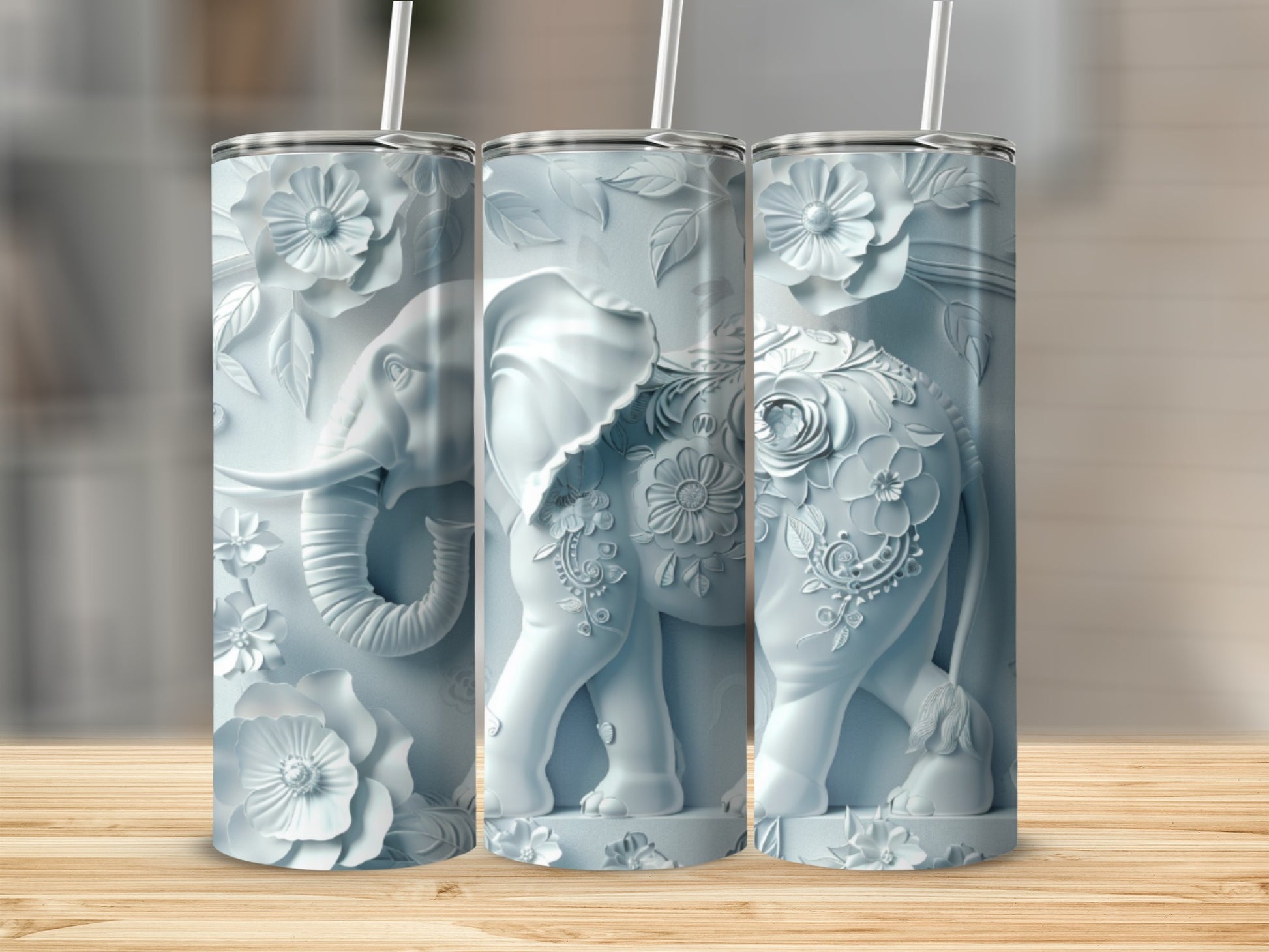 Three light blue tumblers with embossed elephant and floral designs.