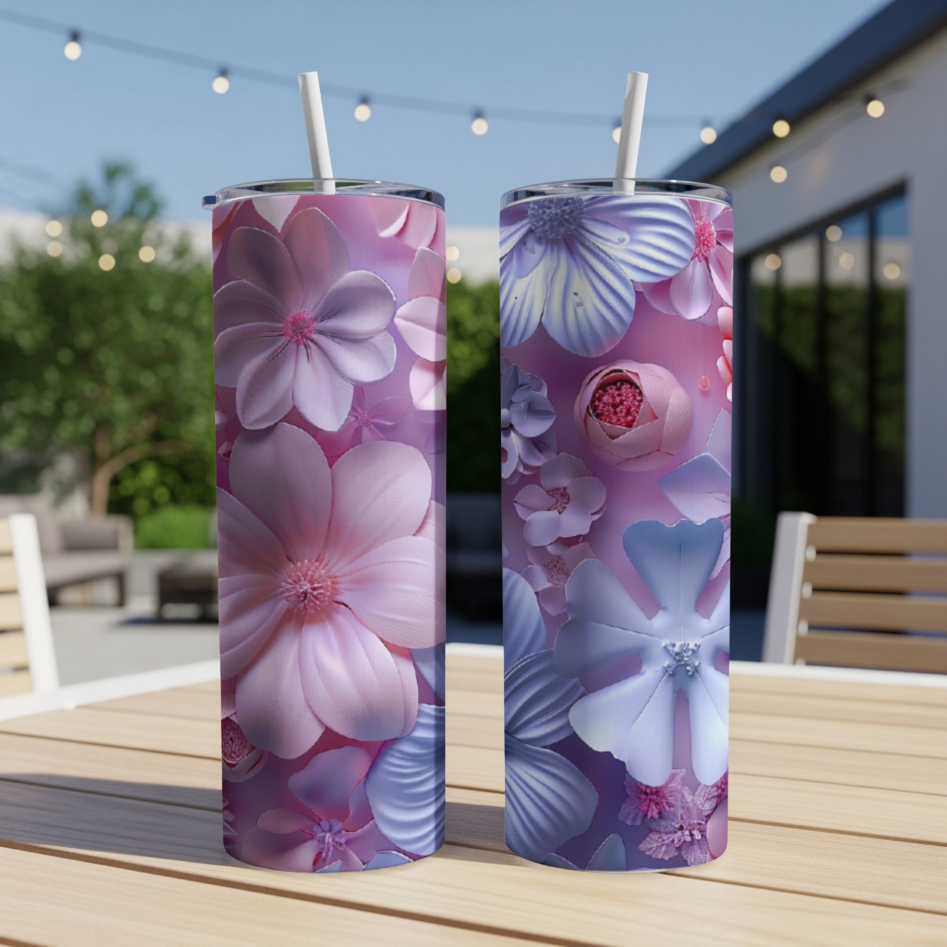 Two tall tumblers with floral designs stand on a table.