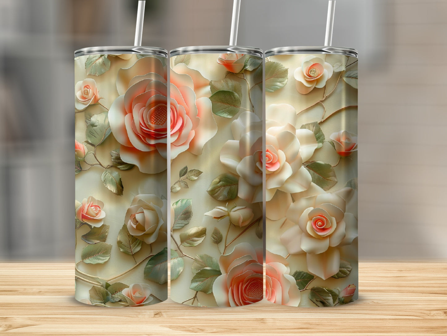Three tumblers with floral rose designs on a wooden surface.