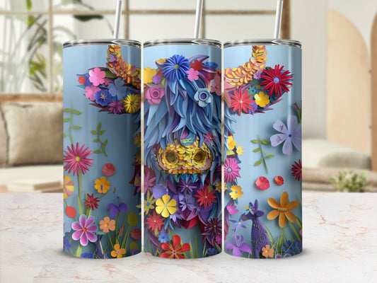 Blue tumbler with a Highland cow's face made of colorful flowers and foliage.