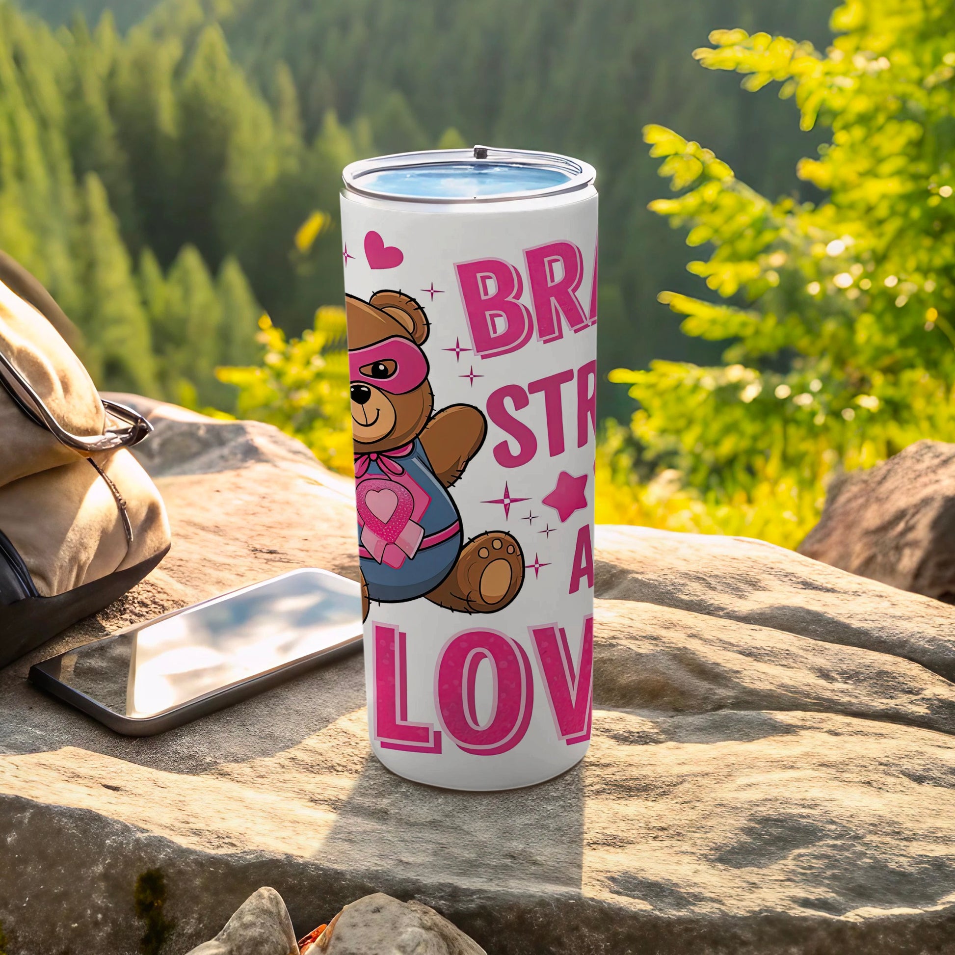 White tumbler with teddy bear superhero and pink text "BRAVE STRONG LOV".