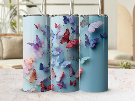 Three tumblers decorated with colorful butterflies in a light blue and pink gradient.