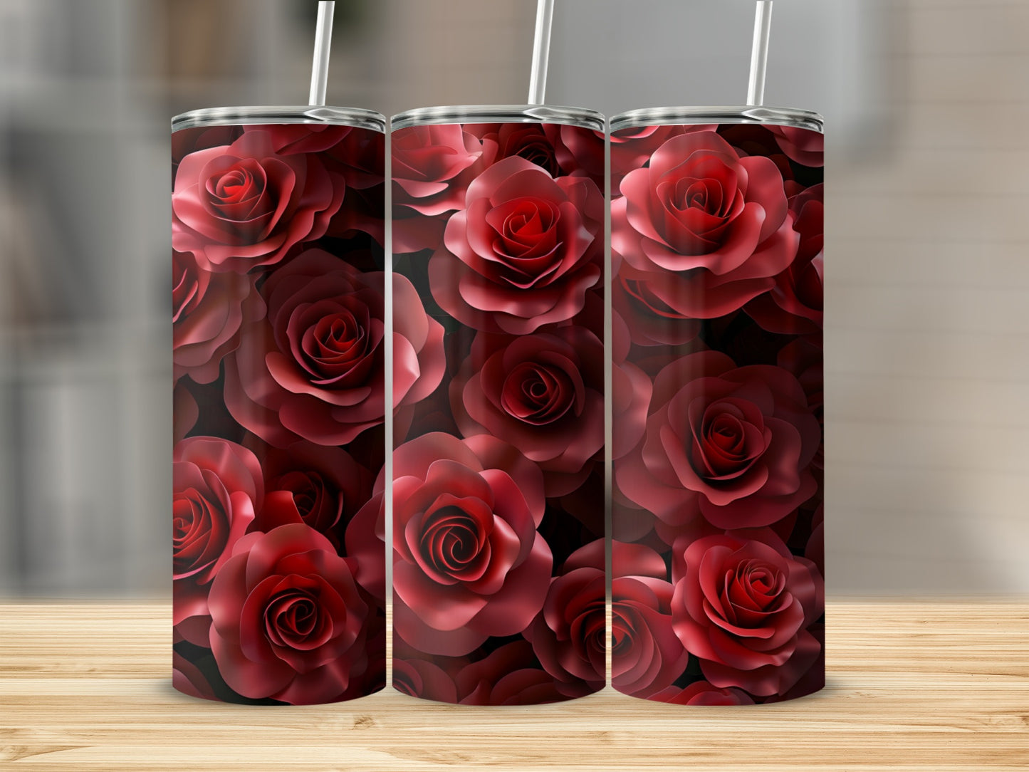 Three tumblers with a repeating pattern of dark red roses on a wooden surface.