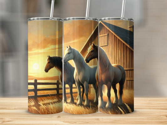 Three horses stand in a field at sunset next to a barn.