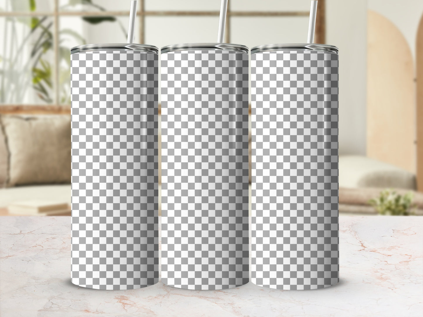 Three blank checkered tumblers with straws on a marble surface.