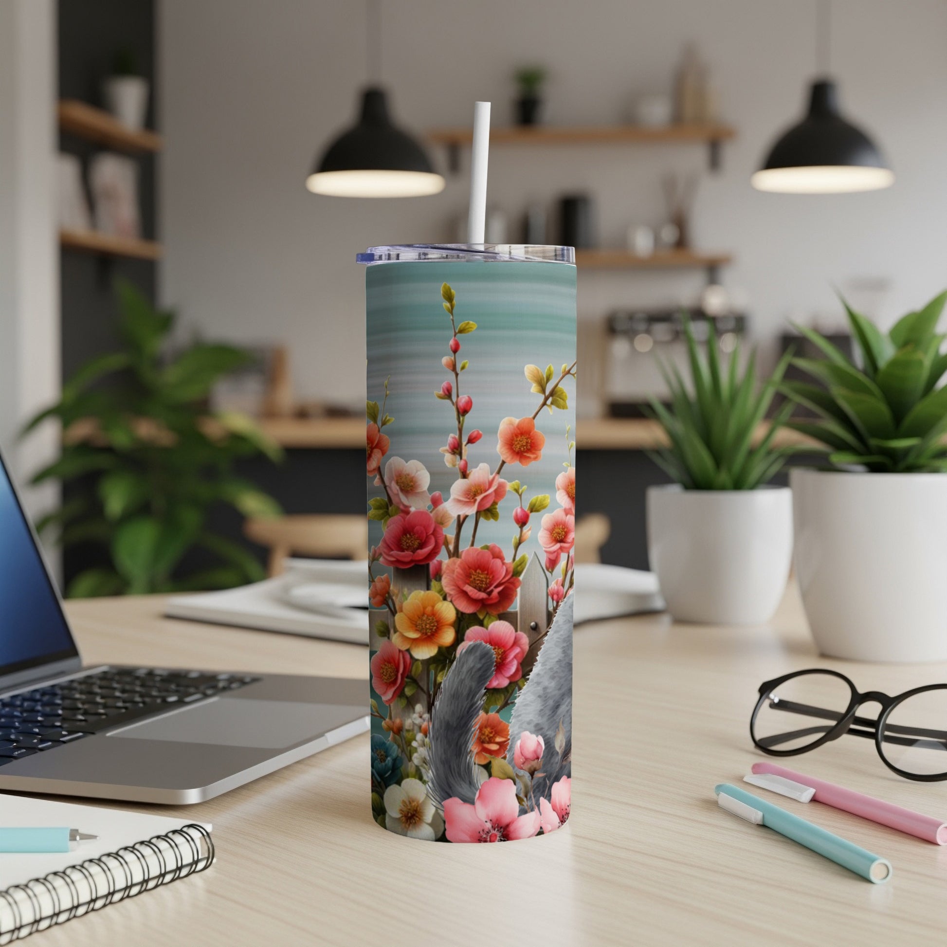 Gray cat partially obscured by colorful floral pattern on a white tumbler.