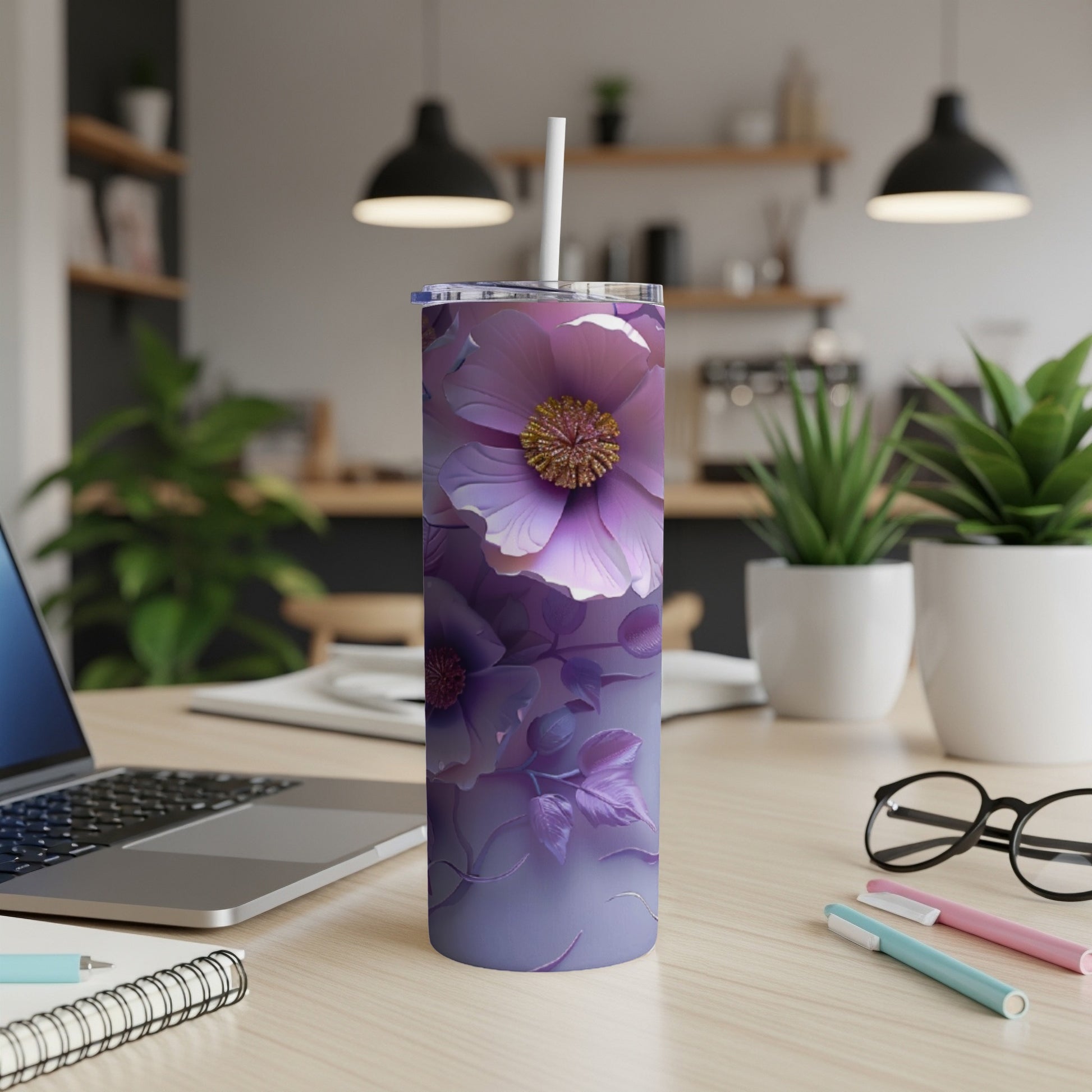 Purple floral skinny tumbler with straw on a desk.