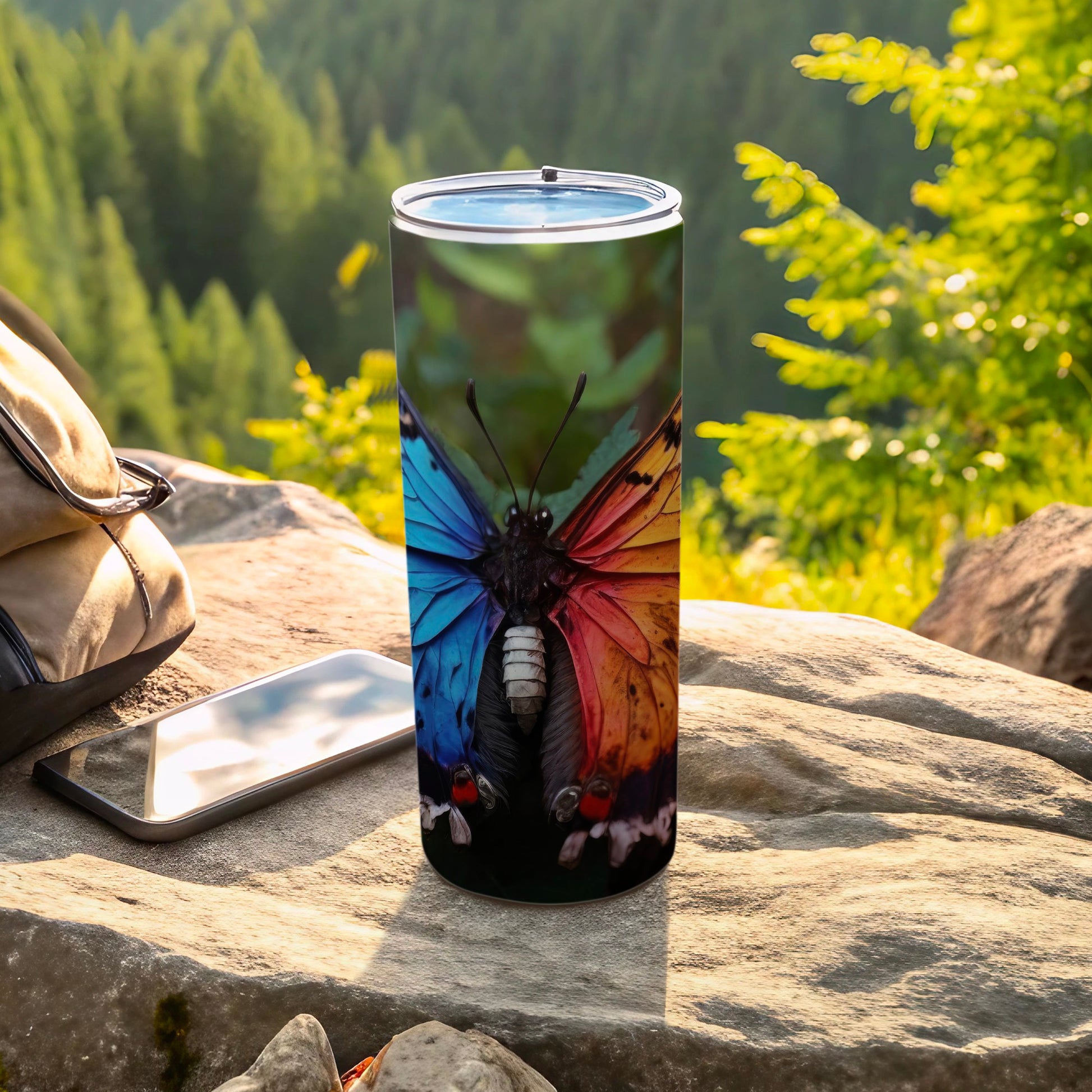 Tumbler with detailed butterfly wing design, outdoors setting.