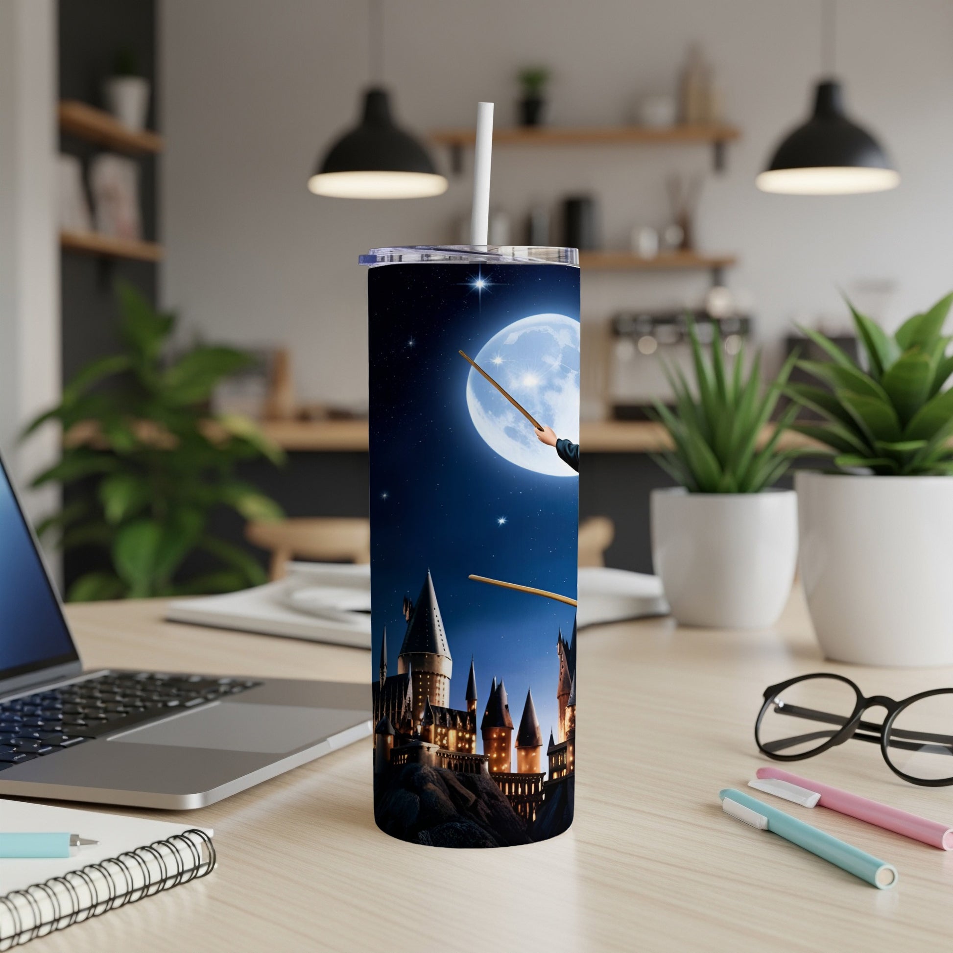 Hogwarts castle under a full moon on a blue tumbler with a white straw.