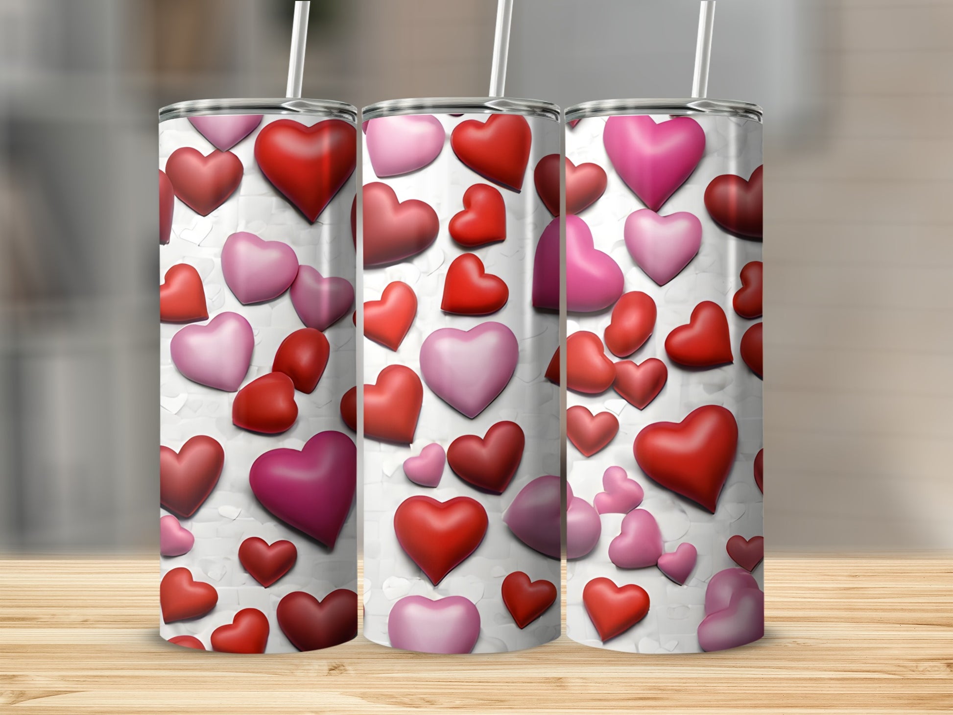 Three tall tumblers with a repeating pattern of red and pink hearts.