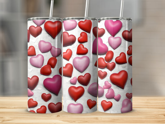 Three tall tumblers with a repeating pattern of red and pink hearts.