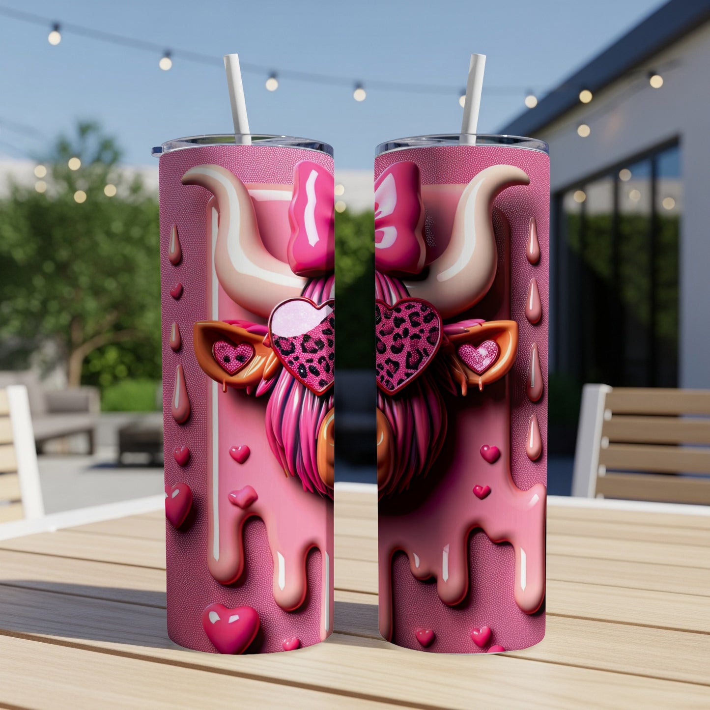 Pink cow tumbler with heart and bow accents, on a table outdoors.