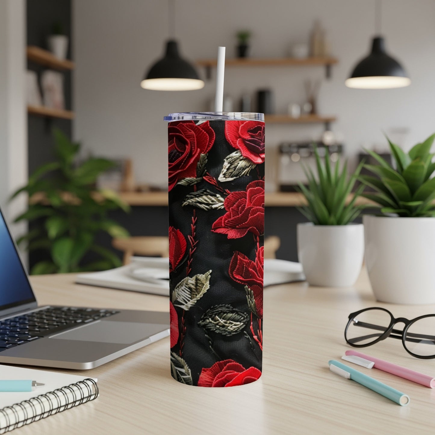 Red rose floral pattern on a black tumbler with a straw.