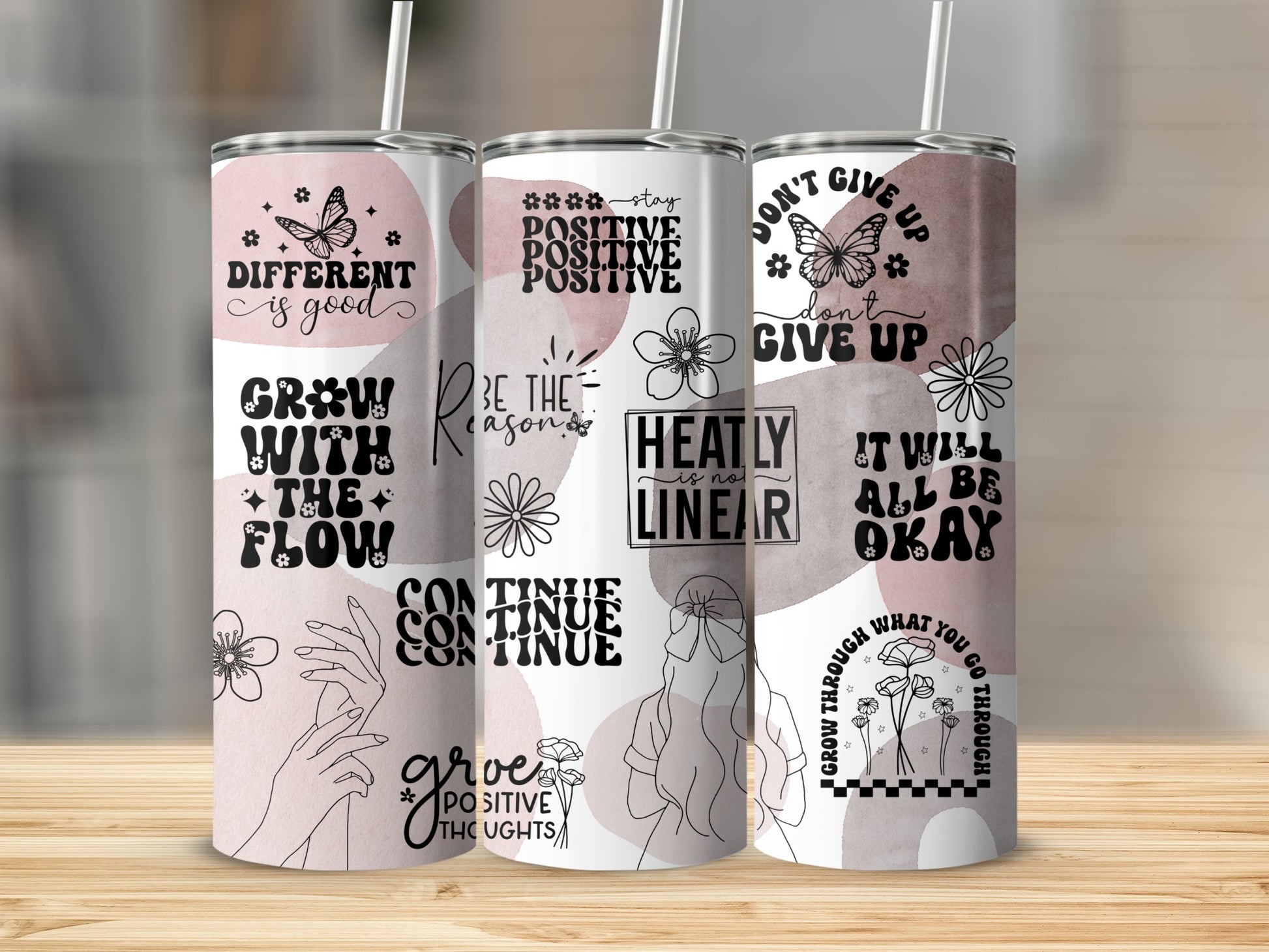 Three tumblers with inspirational quotes and floral designs.