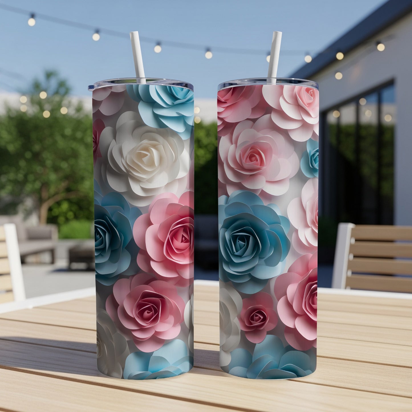 Two tumblers with pink, blue, and white rose designs on a wooden table.