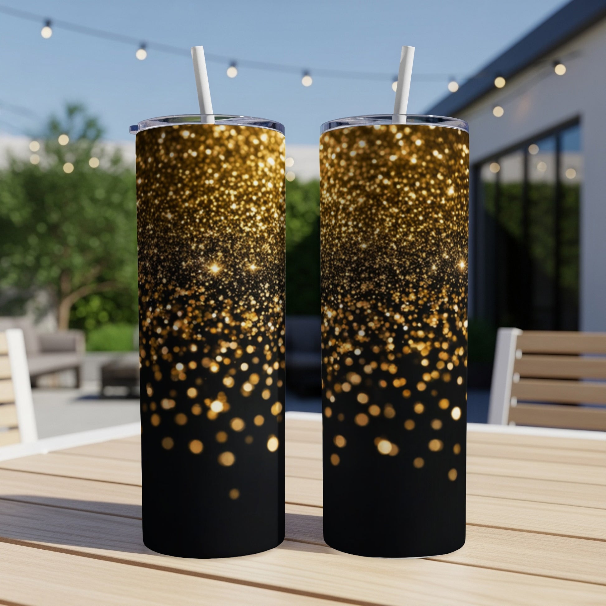 Two black tumblers with gold glitter gradient pattern and white straws.