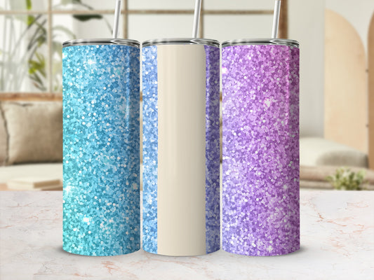Three glitter tumblers: blue, beige, and purple, with straws, on a marble surface.