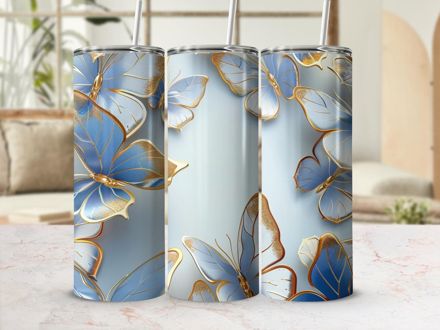 Three blue butterfly tumblers with gold accents on a light marble surface.