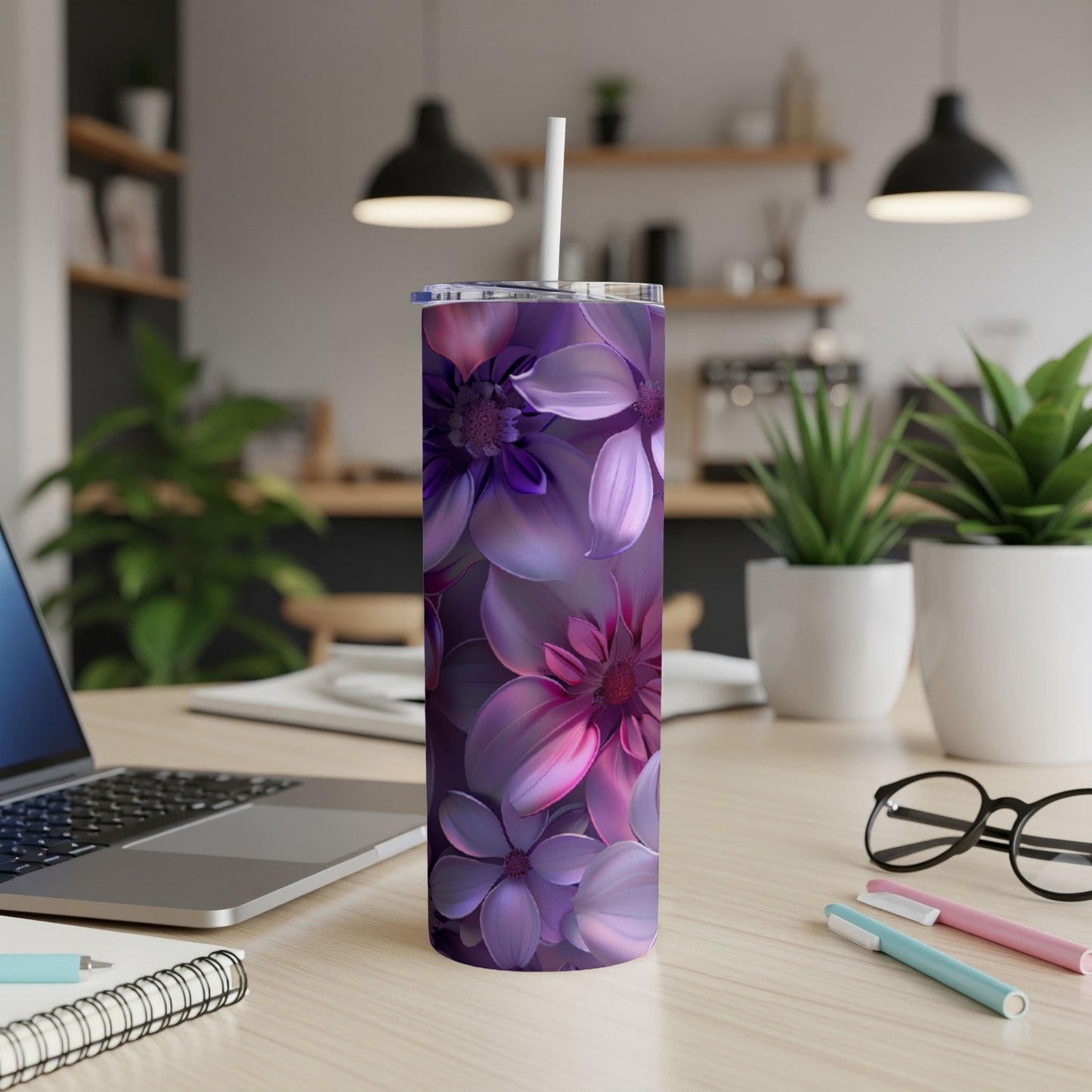 Purple floral tumbler with straw on a desk.
