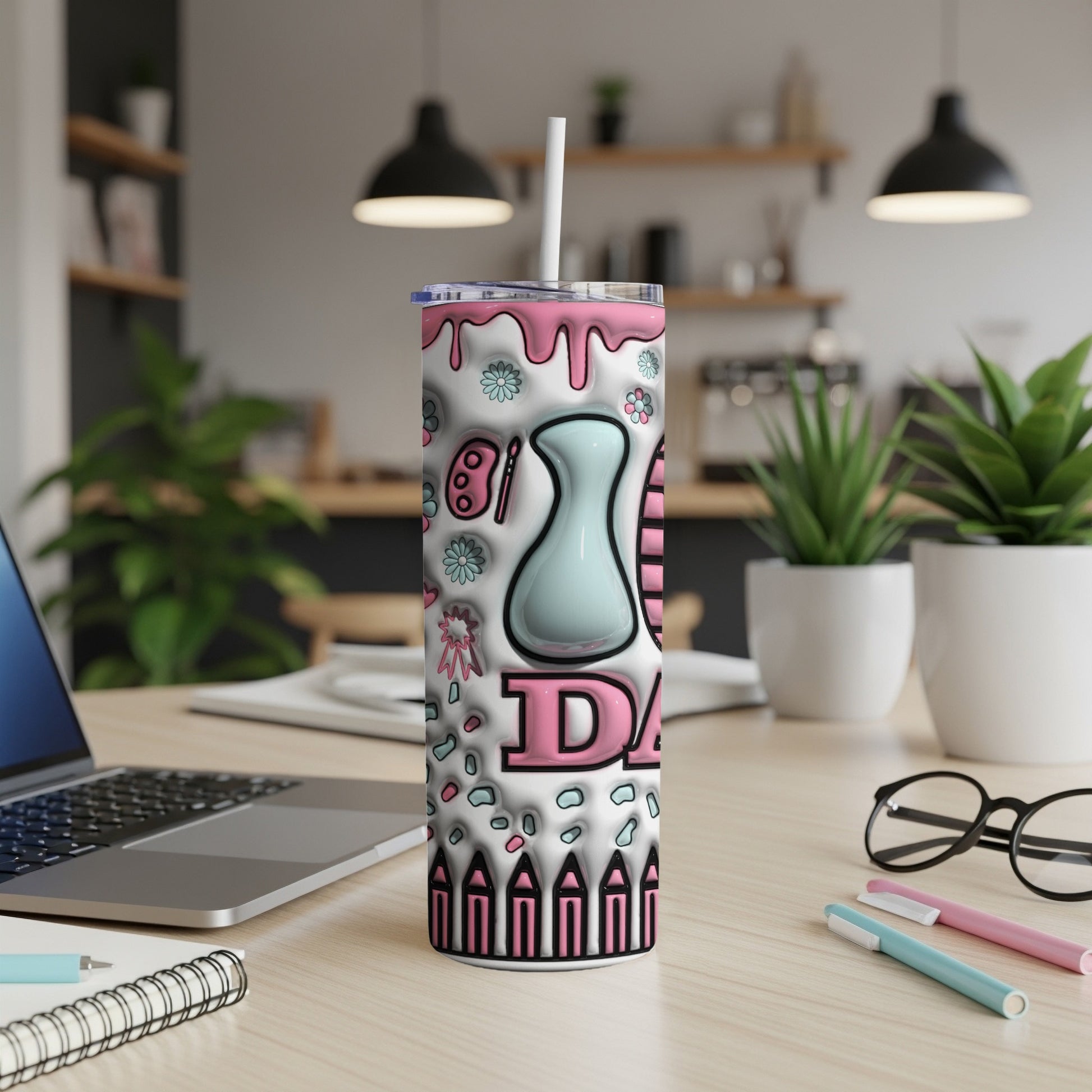 White tumbler with pink and blue artistic designs and the word "DAISY".