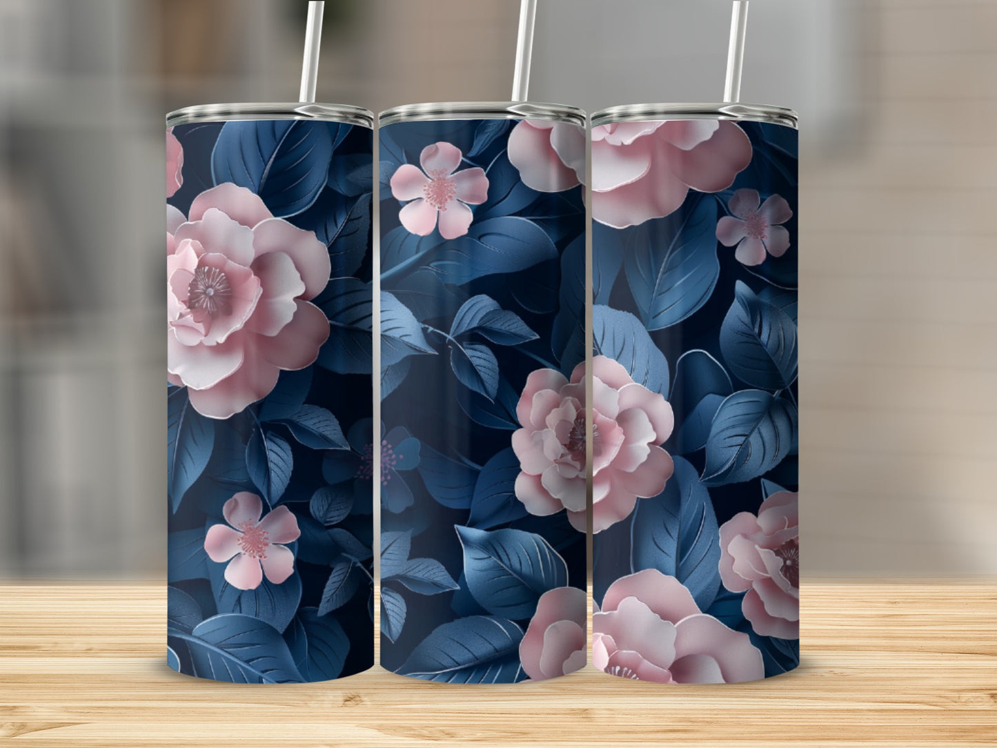 Floral pattern travel tumbler with straw on a wooden surface.